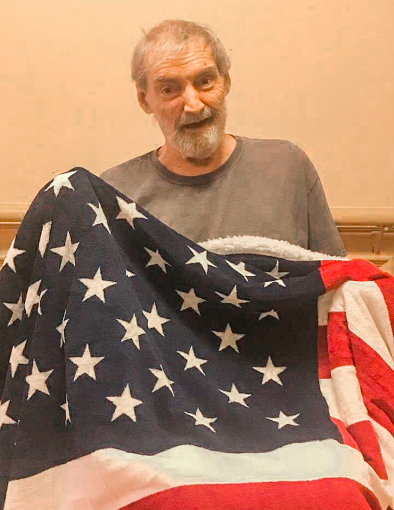 Constellation Veteran Hospice Patient Holds American Flag
